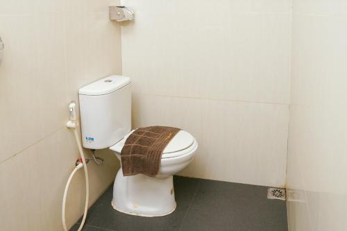 a bathroom with a toilet with a towel on it at Golden Gate Hotel in Bagam