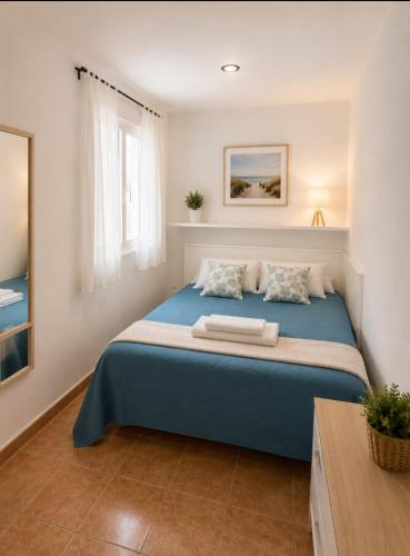 a large blue bed in a room with a window at St Jordi Hagdigadar Tossa in Tossa de Mar
