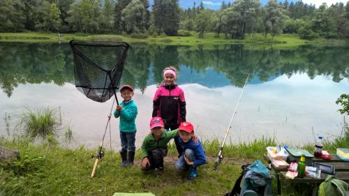 a group of children and a woman standing in front of a lake at Haus Silke in Silbertal