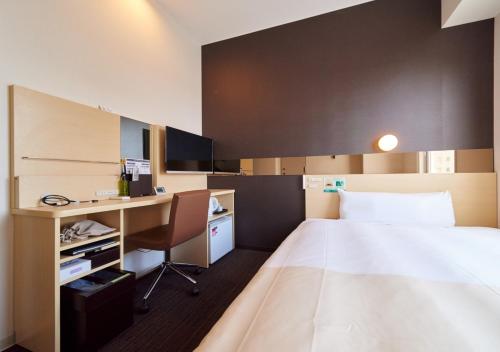 a hotel room with a bed and a desk at Super Hotel JR Nara Ekimae Sanjo Dori in Nara
