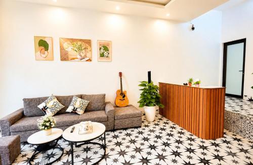 a living room with a couch and a guitar at Sweet Apartment Sa Pa in Sapa