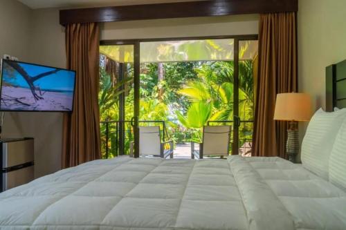 a bedroom with a large bed and a large window at Buena Vista Plus in Quepos