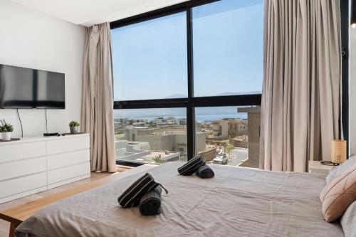 a bedroom with a large bed with a large window at Villa Marbella Eilat in Eilat