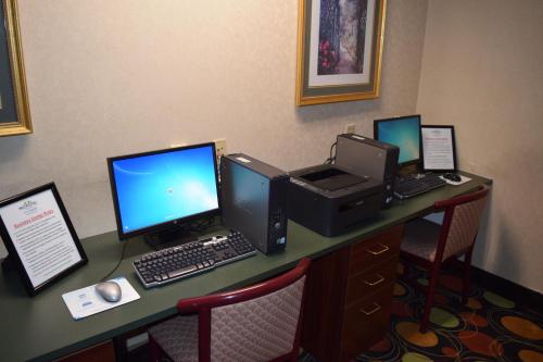 a desk with three monitors and a computer on it at Microtel Inn & Suites by Wyndham Rock Hill/Charlotte Area in Rock Hill