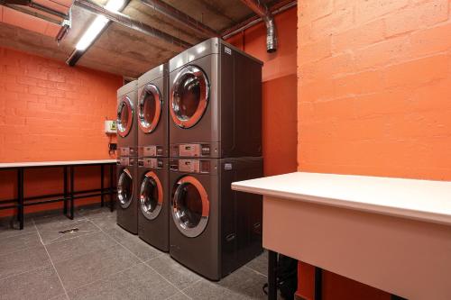 a laundry room with three washing machines in it at THREE43 ON B - Fluent Serviced Apartments in Cape Town