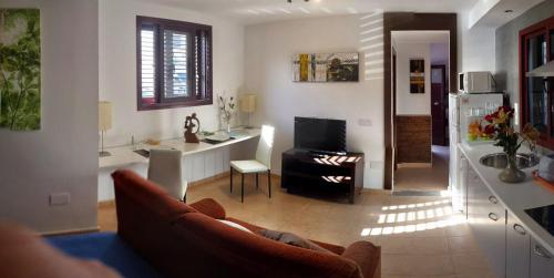 a living room with a couch and a kitchen at Residential Majada Apartments in Puerto del Rosario