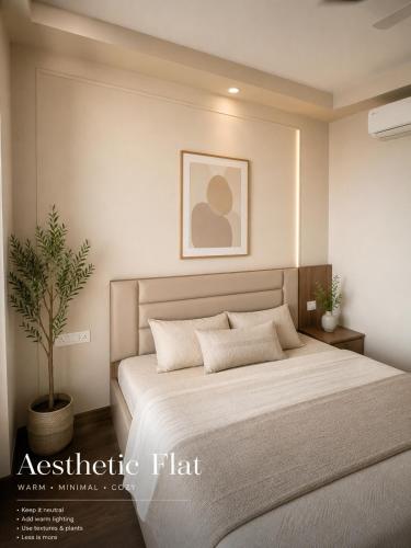a bedroom with a large bed and a plant at Luxura stays in Greater Noida