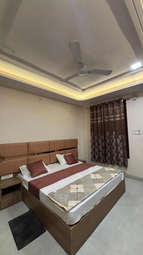 a bedroom with a large bed with a ceiling at Hotel Awadh Grand in Kānpur