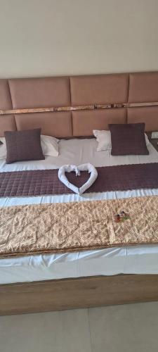 a bed with a pair of white shoes on it at Hotel Awadh Grand in Kānpur