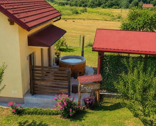 a house with a hot tub next to a yard at Kuća Trota - sauna, HOT TUB in Otočac