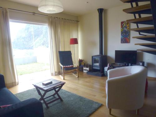 uma sala de estar com um sofá, uma cadeira e uma lareira em CASAS MARE , Ponta Delgada, Madeira em Ponta Delgada