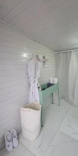 a white bathroom with a green table and a sink at Mothers Modern Lakeside Cabin in Khyaktil