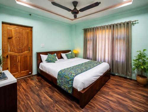 a bedroom with a large bed and a ceiling fan at Hotel Riverwood Kokernag in Wāngom