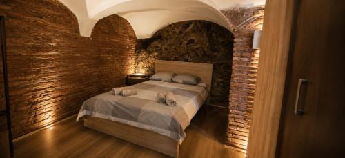 a bedroom with a bed in a brick wall at Moonlight Etna B&B Catania in Catania