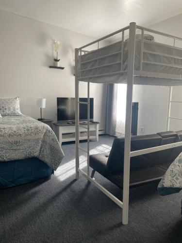 a bedroom with a bunk bed and a television at Ocean Spray Inn in Winthrop