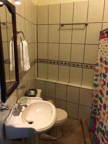 a bathroom with a sink and a toilet at Posada Familiar El Dorado in Xilitla