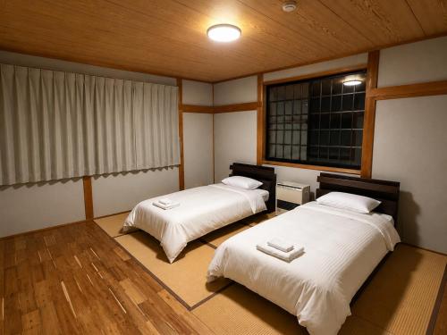 a room with two beds and a window at Daiju Myoko - Renovated in 2025 in Myoko