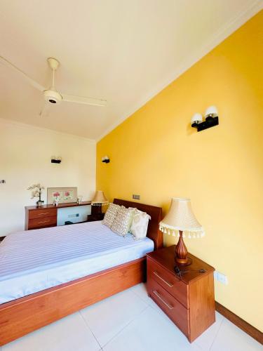 a bedroom with a bed and a lamp on a table at Shek Residence in Colombo