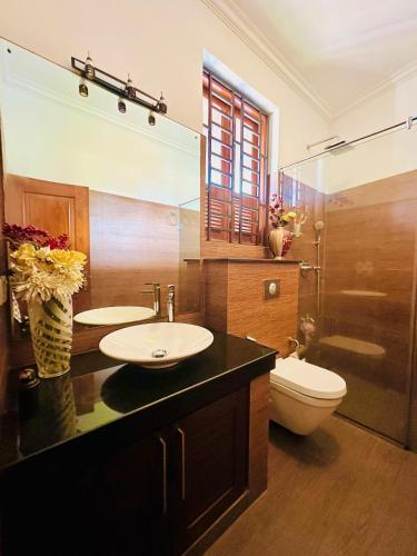 a bathroom with a sink and a toilet and a mirror at Shek Residence in Colombo