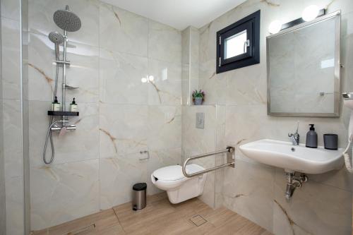 a bathroom with a toilet and a sink and a shower at O-live in Prinos