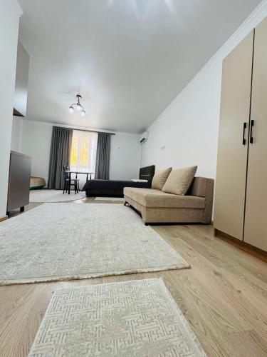 a living room with a couch and a table at Balor152 in Koshkolʼ