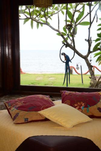 ein Schlafzimmer mit einem Fenster mit einer Statue einer Person in der Unterkunft Brisa Hotel in Caraguatatuba