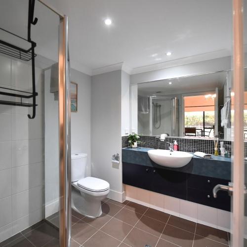 a bathroom with a sink and a toilet and a mirror at Barefoot Bliss in Rockingham