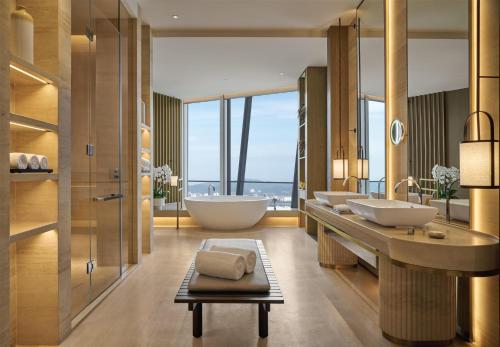 a bathroom with two sinks and a tub and a bath tub at Park Hyatt Kuala Lumpur in Kuala Lumpur