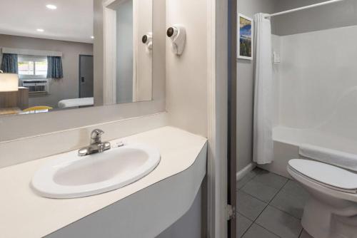 a bathroom with a sink and a toilet at Days Inn by Wyndham Moosic in Moosic
