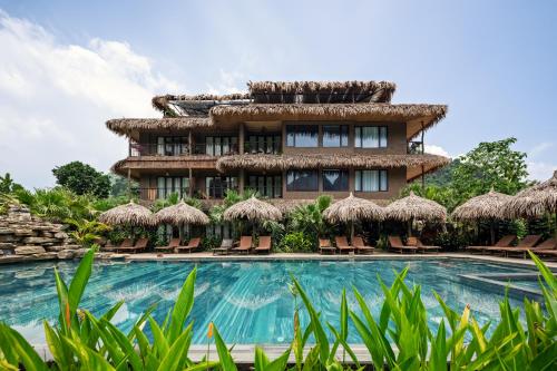 a resort with a swimming pool and a building at Tam Coc Oasis Resort & Spa in Ninh Binh