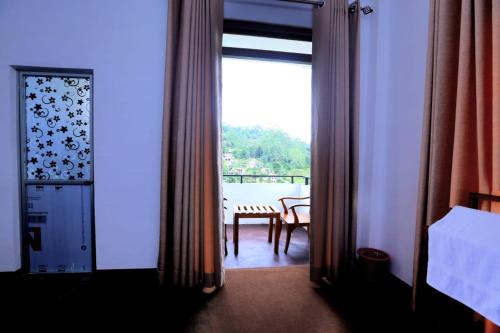 a room with a door open to a balcony with a table at Lush Home in Bandarawela