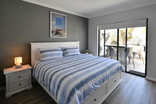 a bedroom with a bed with a blue and white comforter at Barefoot Bliss in Rockingham