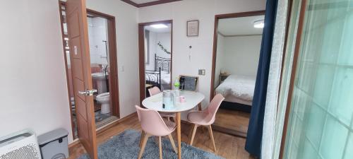 a small room with a table and chairs and a bed at Lunar House in Hyomoktong-Ilgu
