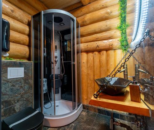 a bathroom with a shower in a wooden wall at Barlogul Ursului in Baia Mare