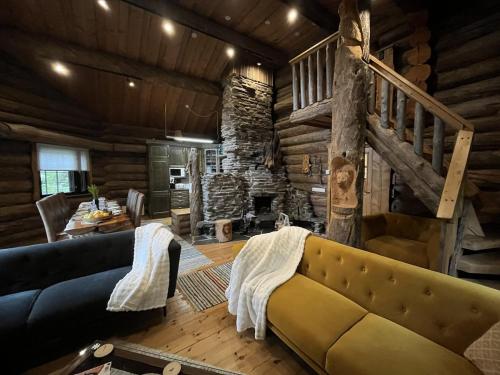 a living room with a couch and a stone fireplace at Villa Pukelo Arctic Lodge with wifi sauna 4 poster bed fireplace in Salla