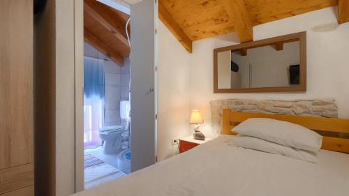 a bedroom with a white bed and a mirror at Lukini dvori by Villas Guide in Bibići