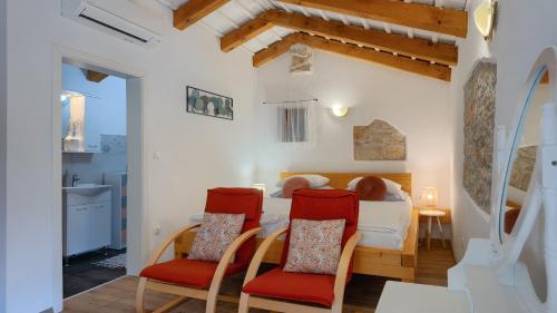 a bedroom with a bed and chairs in a room at Lukini dvori by Villas Guide in Bibići