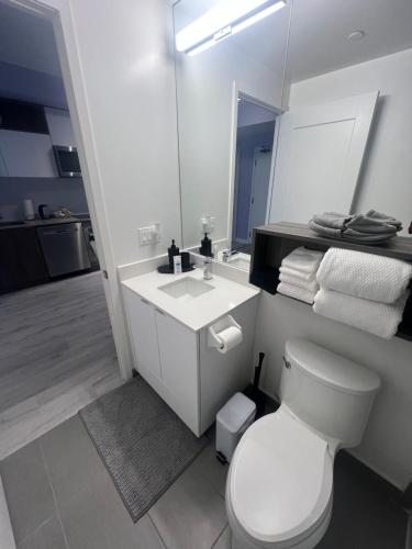 a bathroom with a white toilet and a sink at Downtown Luxury Condo Gym & Parking in Toronto