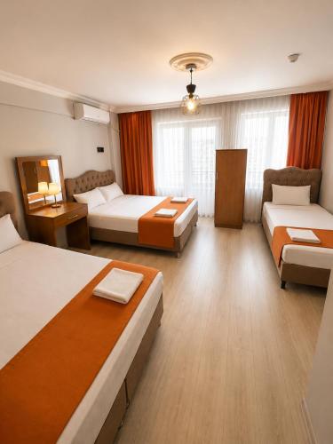 a hotel room with two beds and a couch at Kennedy Apart Hotel Kumkapı Istanbul in Istanbul