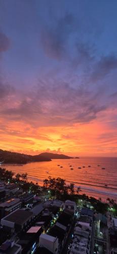 a sunset over a city and the ocean with buildings at PATONG TOWER Residence Apartments 2026 in Patong Beach