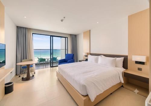 a bedroom with a bed and a view of the ocean at The Sea Beach Residences - Arena Cam Ranh Resort in Cam Ranh International Airport