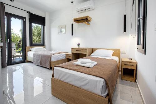 a hotel room with two beds and a balcony at O-live in Prinos