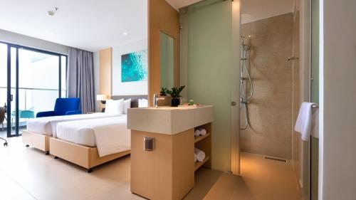 a hotel room with a bed and a shower at The Sea Beach Residences - Arena Cam Ranh Resort in Cam Ranh International Airport