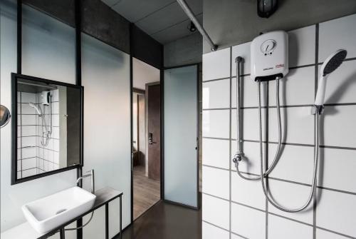 a bathroom with a shower and a sink and a mirror at Westory Design Poshtel in Kanchanaburi City