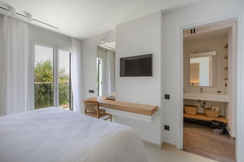a bedroom with a bed and a desk and a mirror at Elea Beach Hotel in Dassia