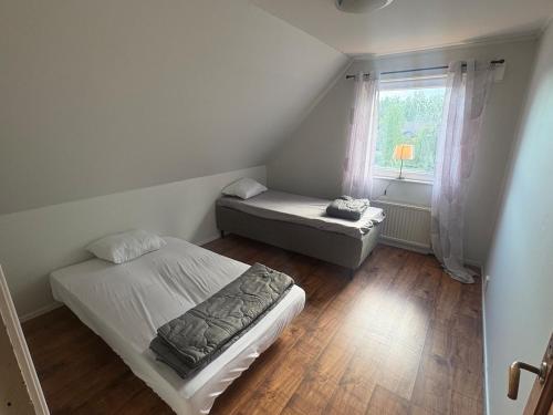 a small bedroom with two beds and a window at Villa Konga in Konga