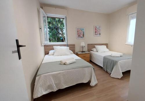a bedroom with two beds and a cross on the wall at La Casina de L'Aspu in Luces
