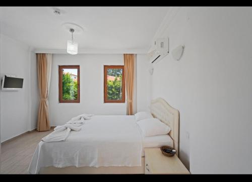 a white bedroom with a bed and a couch at Arzu otel apart in Datca