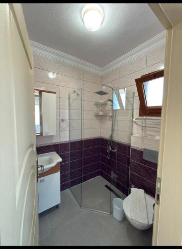 a bathroom with a shower and a toilet and a sink at Arzu otel apart in Datca