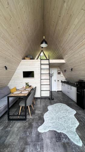 a living room with a table and a kitchen at Forest Huts in Yablunytsya